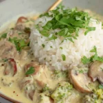 Creamy mushroom gravy with rice and parsley garnish